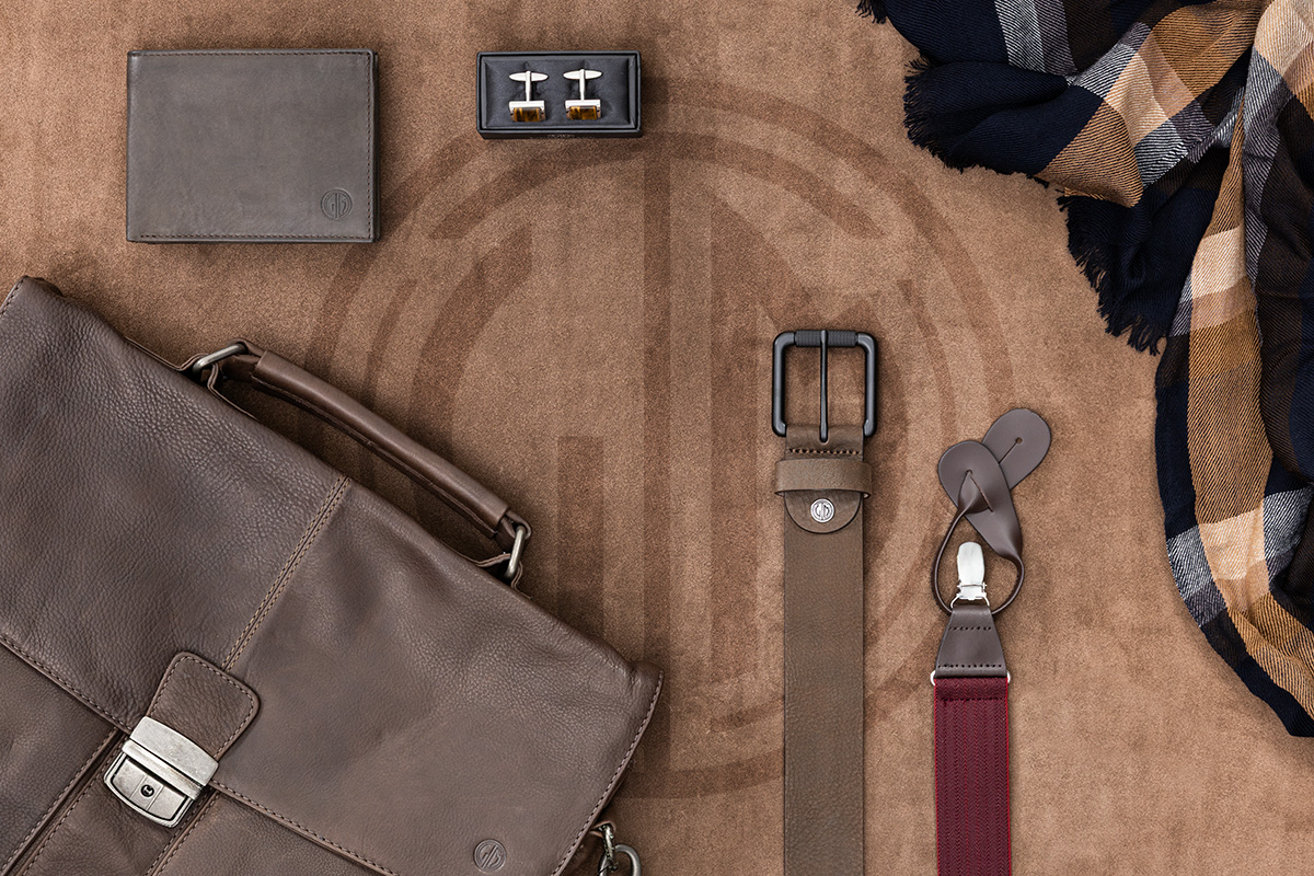 Lindenmann Accessoires auf braunem Hintergrund – Gürtel aus Leder, Tasche, Geldbeutel, Hosenträger und Manschettenknöpfe