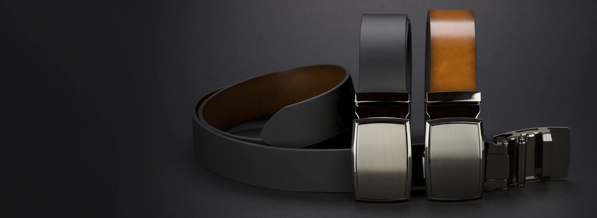 Zwei Gürtel in Schwarz und Braun mit metallischen Schnallen